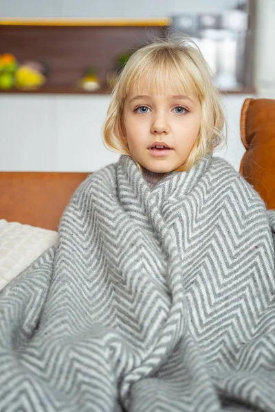 Adorabile bambina seduta sul divano a casa — Foto Stock