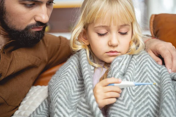 Padre e hija mirando el termómetro digital —  Fotos de Stock