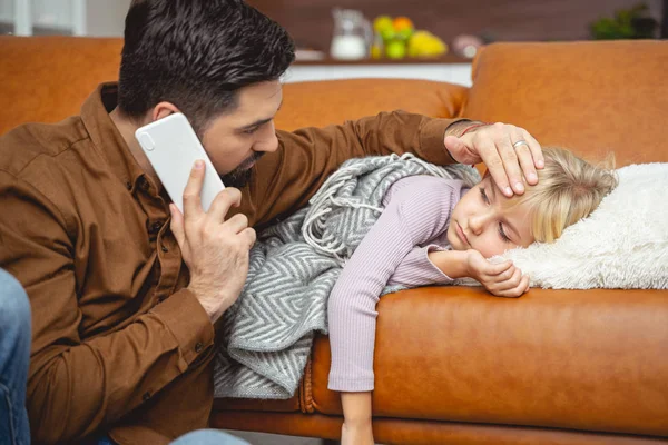Caring father calling doctor and touching daughter forehead — Stock Photo, Image