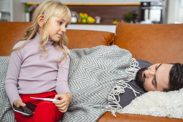 Little girl checking father temperature with thermometer — 스톡 사진