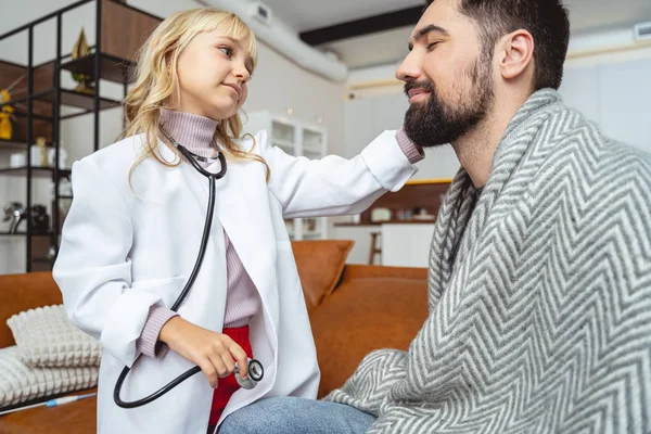 Söta barn leker läkare med sin leende far — Stockfoto