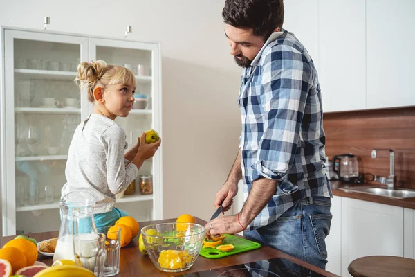 Liten flicka tittar på hur pappa matlagning och prata på mobiltelefon — Stockfoto