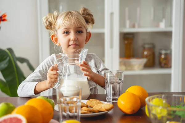 Nettes kleines Mädchen sitzt zu Hause am Küchentisch — Stockfoto