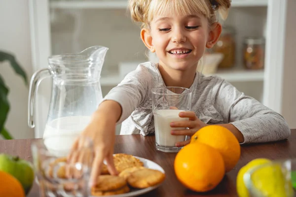 Linda niña tomando galletas y sonriendo —  Fotos de Stock