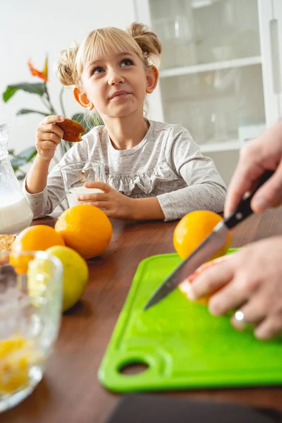 Aranyos kislány, aki sütit tart és nézi apát. — Stock Fotó