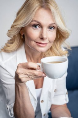 Placid pleasant lady having a tea break