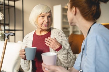 Kind mature female person listening to her doctor