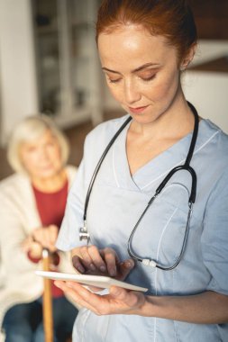 Serious female person looking at screen of her gadget