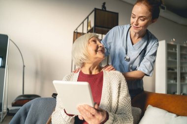 Pleased blonde woman looking at her doctor
