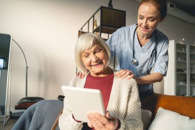 Positive delighted pensioner demonstrating her new tablet