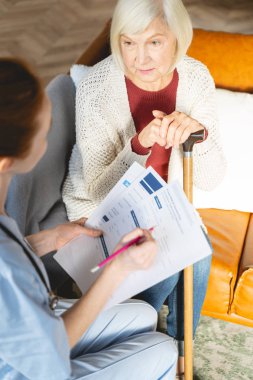 Attentive blonde female person looking at her doctor