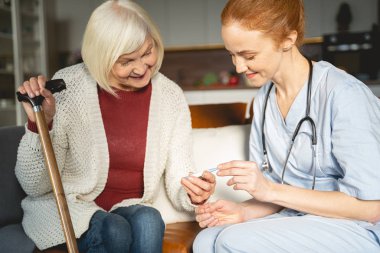 Kind senior female person looking at thermometer