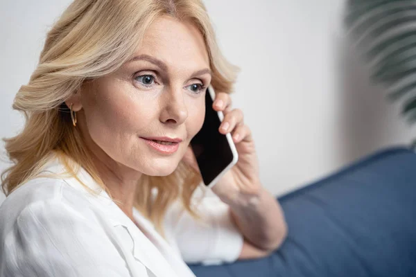Серьёзная женщина средних лет разговаривает по телефону — стоковое фото