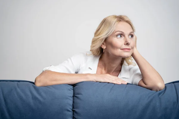 Женщина прислонилась локтем к дивану — стоковое фото
