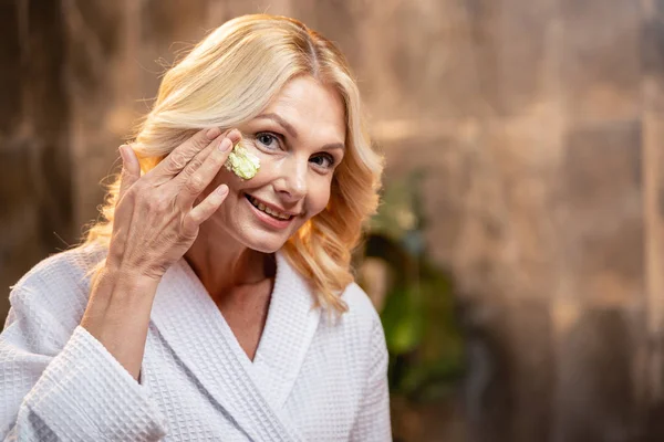 Zufriedene Frau mit einem Hautpflegeprodukt — Stockfoto