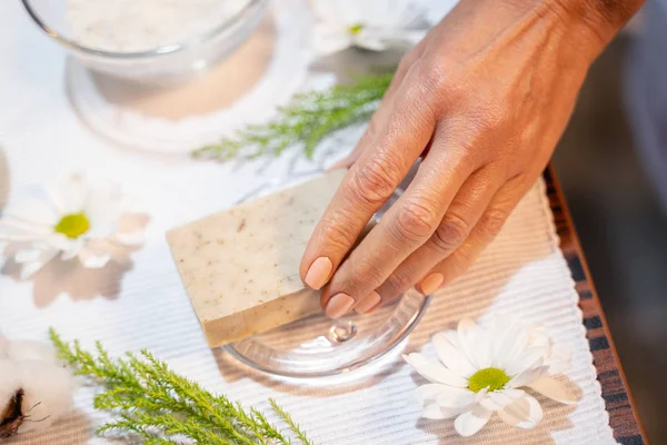 Женская рука берет косметическое мыло со стола — стоковое фото