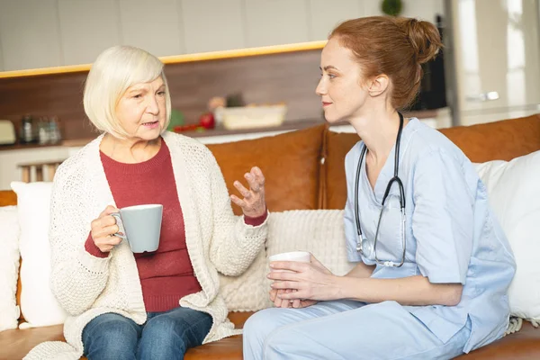 Dos mujeres tomando un descanso para tomar el té durante la conversación — Foto de Stock