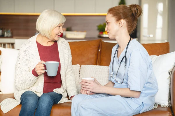 Positieve opgetogen jonge arts die haar patiënt raadpleegt — Stockfoto