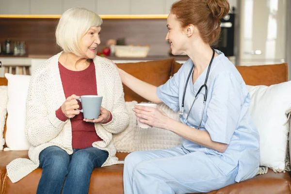 Vrolijke volwassen vrouwelijke persoon praten met haar arts — Stockfoto