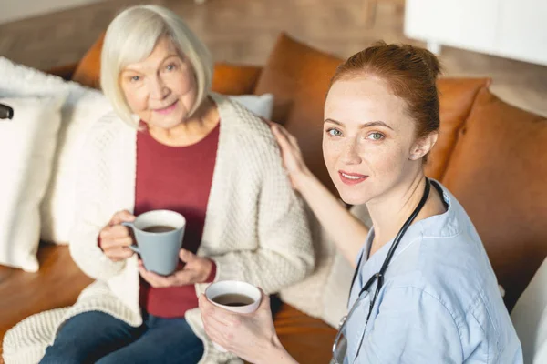 Attractive young medical worker taking care of her granny — Stock Photo, Image