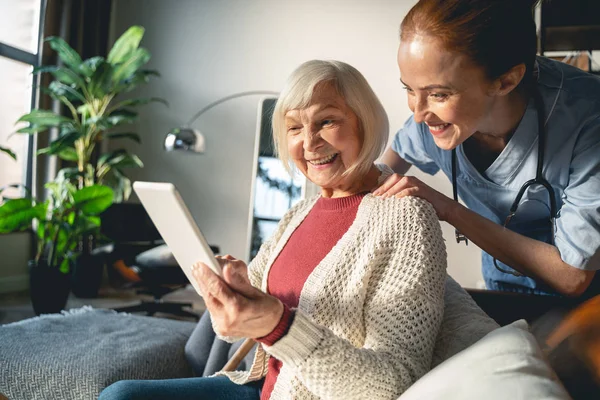 Positivo persona madura encantada utilizando el nuevo dispositivo — Foto de Stock