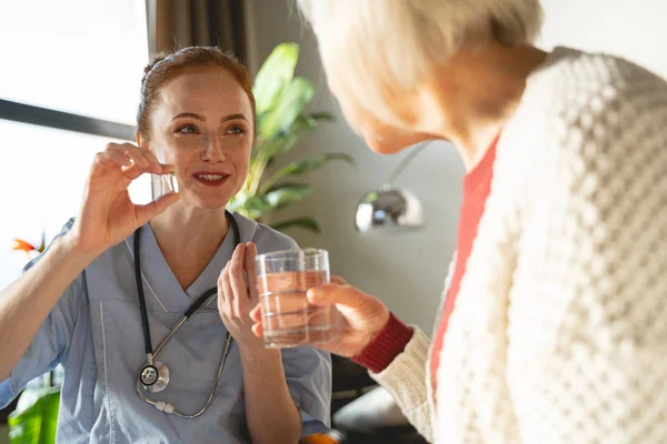 Веселая медицинская работница консультирует своего взрослого пациента — стоковое фото