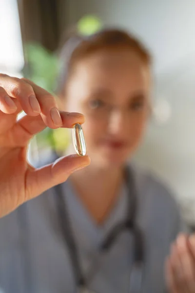 Photo concentrée sur la main féminine qui tient la capsule — Photo