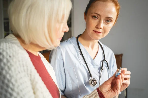 Cute medical worker checking temperature of her patient