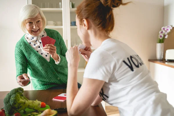 En lykkelig pensjonist som snakker med sin frivillige. – stockfoto