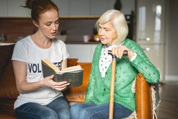 Jovem atenta pessoa feminina lendo a Bíblia Sagrada — Fotografia de Stock