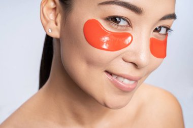 Stüdyoda poz veren yüzü yamalı hoş bir genç kadın.