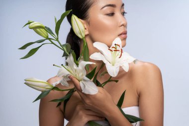 Stüdyoda güzel bir buketle poz veren çekici sakin bayan.