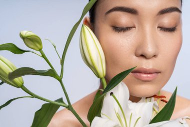 Stüdyoda güzel bir buketle poz veren kapalı gözlü güzel bayan.