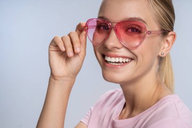 Stüdyoda kameraya poz veren gülümseyen beyaz kız.