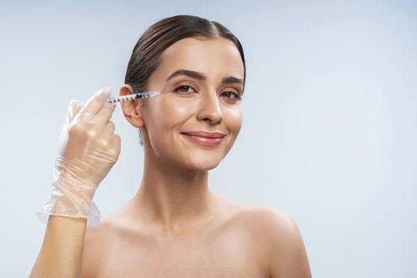 Charming Caucasian girl is ready for beauty procedures against light background — Stock Photo, Image