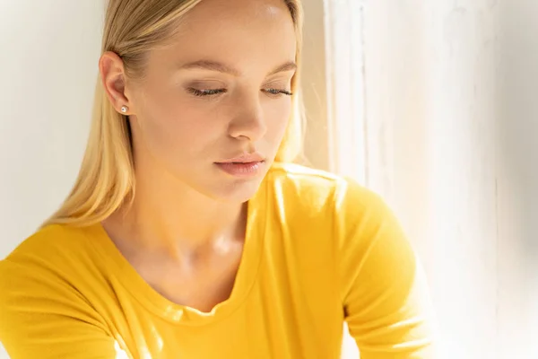 Tineri femeie frumoasă în pulover galben care pozează pentru cameră acasă — Fotografie, imagine de stoc