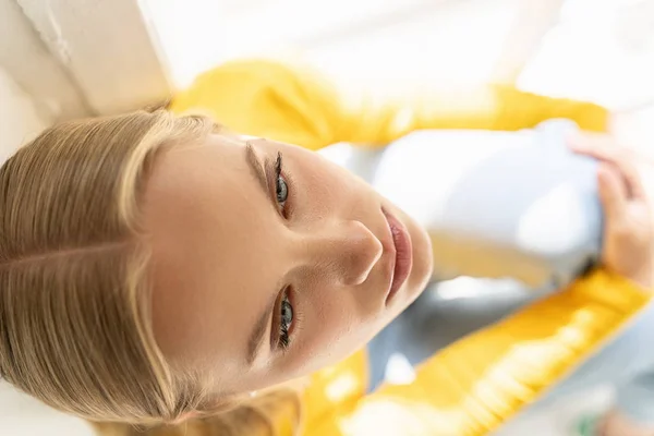 Senhora concentrada em suéter amarelo posando para câmera em casa — Fotografia de Stock