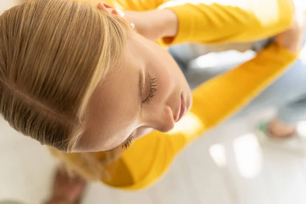 Concentrated lady in yellow jumper posing for camera at home — 스톡 사진