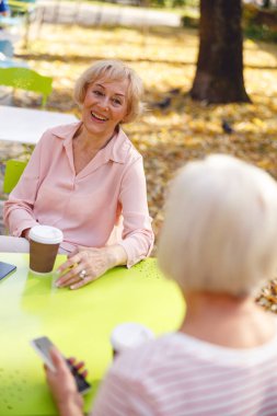 Kadınlar gülerek parklarda vakit geçiriyorlar.