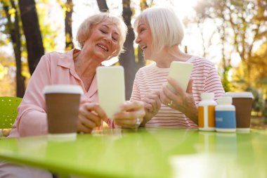 Mutlu arkadaşlar birbirlerine yeni cihazlarını gösteriyor.