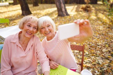 Mutlu eski dostlar birlikte hatıra fotoğrafı çekiyorlar.