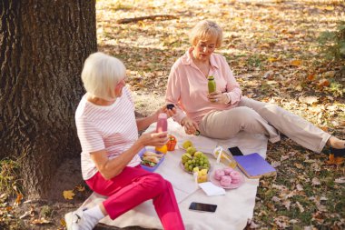İki mutlu arkadaş sabah pikniğinin tadını çıkarıyor.