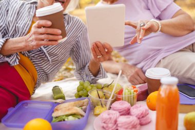 Parkta modern teknolojileri tartışan arkadaşlar