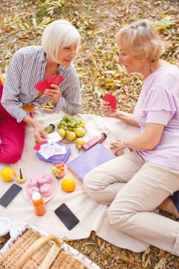 Parkta kağıt oyunu kazanan mutlu bayan.
