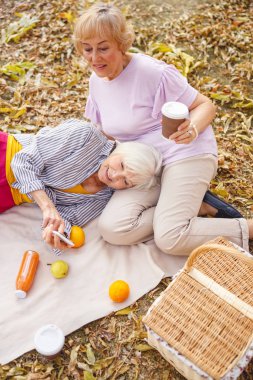 Neşeli kadın akıllı telefonuyla müzik açıyor.