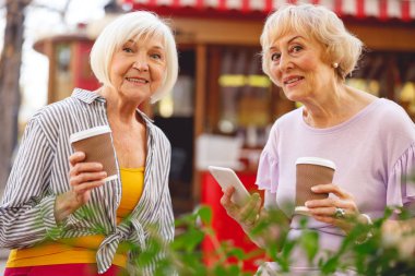 İki kadın sabah kahvelerini bir kafede içiyorlar.