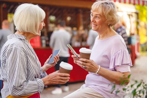 Barátok élvezik a beszélgetést egy utcai kávézóban — Stock Fotó
