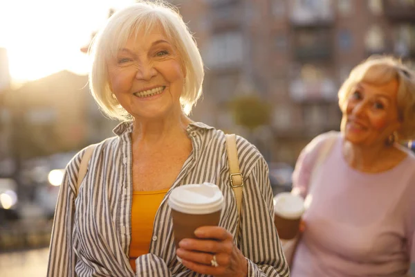 Happy old friends walking through the city together