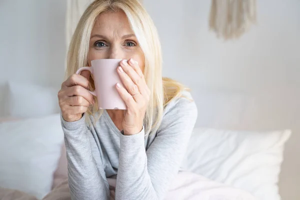 Mujer en casa disfrutando de bebidas calientes foto de stock — Foto de Stock