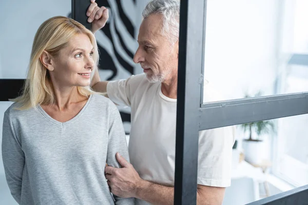 Mujer sonriente amablemente mirando hombre stock foto — Foto de Stock